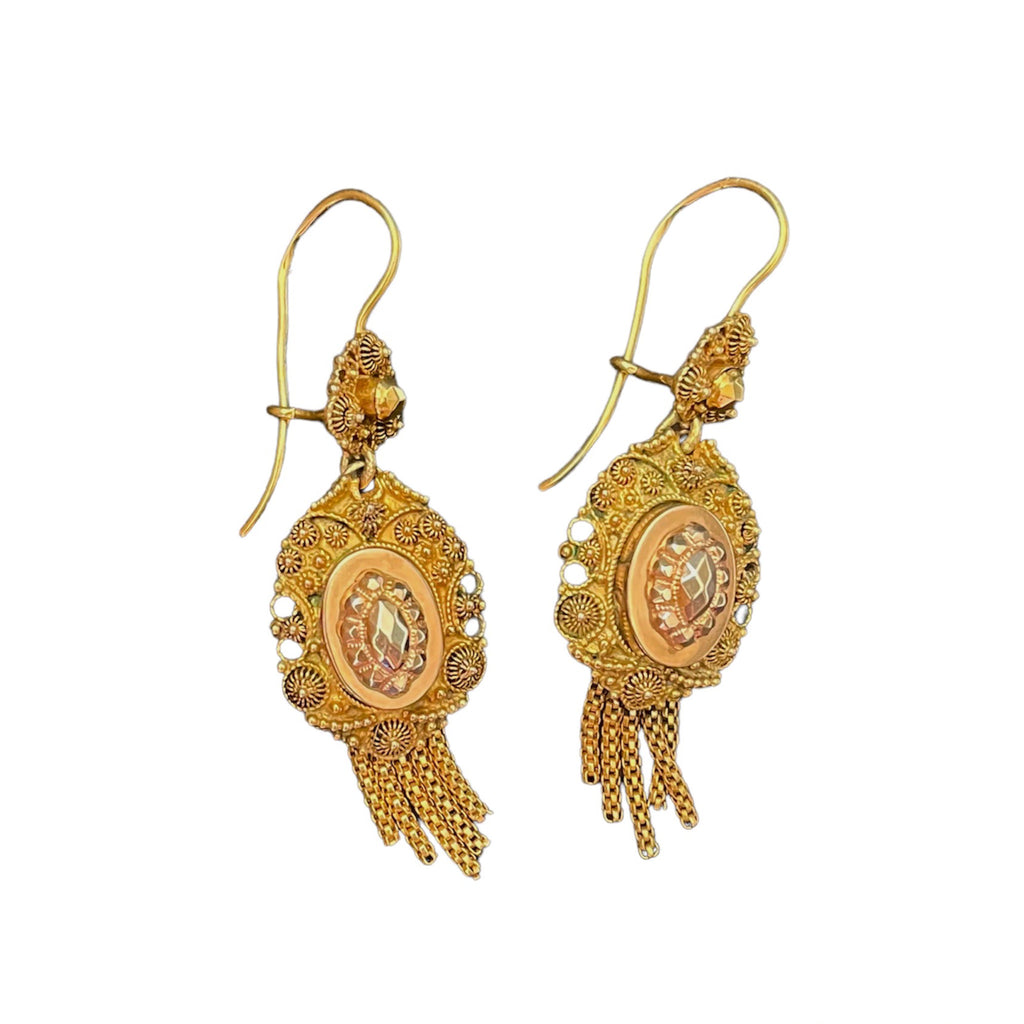 Warm gold filigree earrings intricately adorned with detailed carvings, shapes, and tassels.
