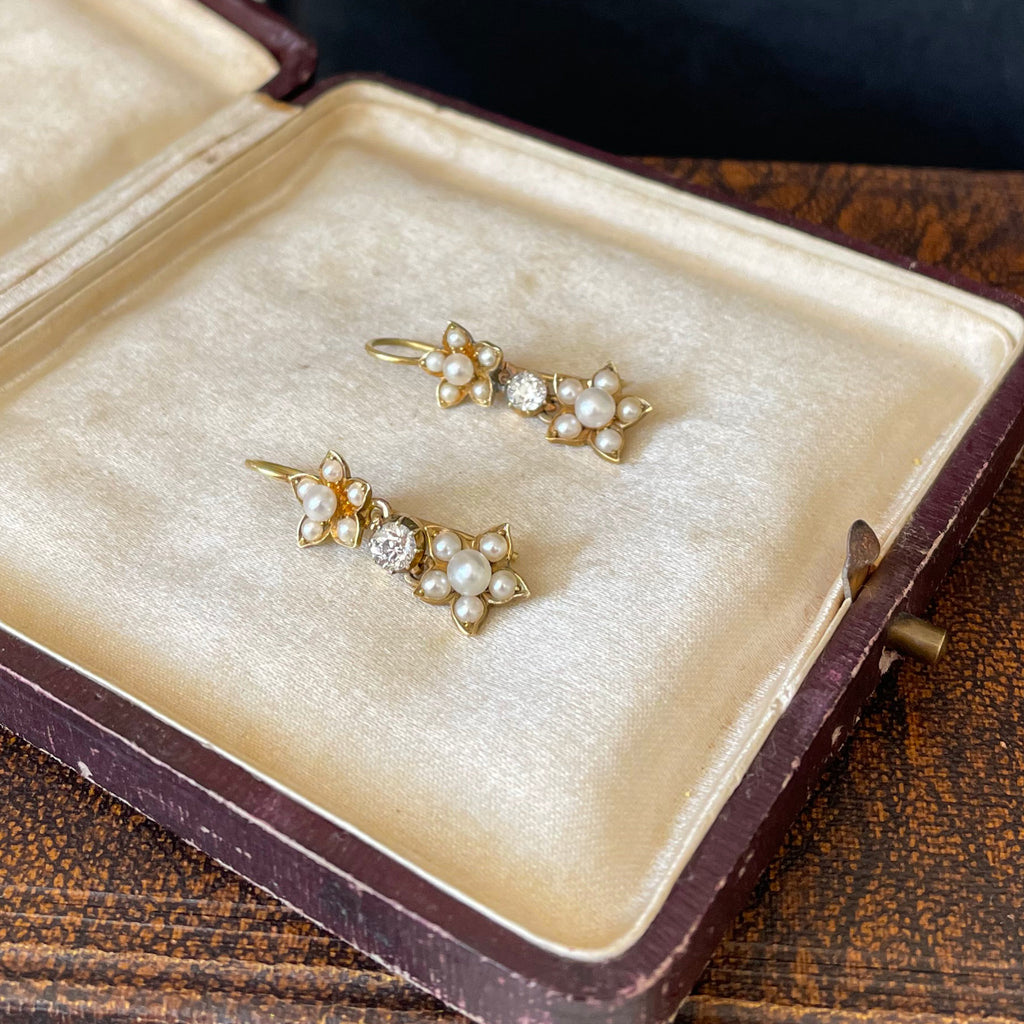 Gold flowers with pearls and diamonds in antique jewellery box of ivory silk.
