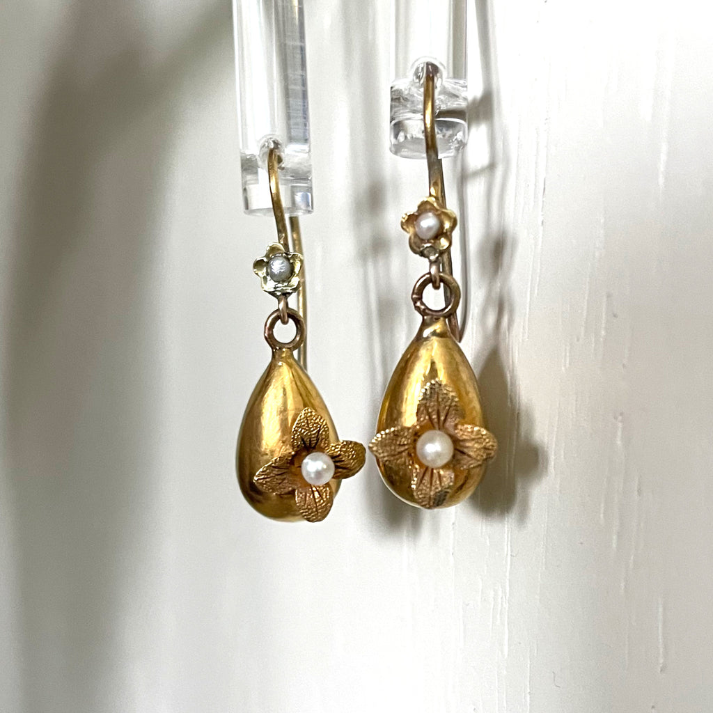 Rich gold earrings made of gold with pearl flowers.