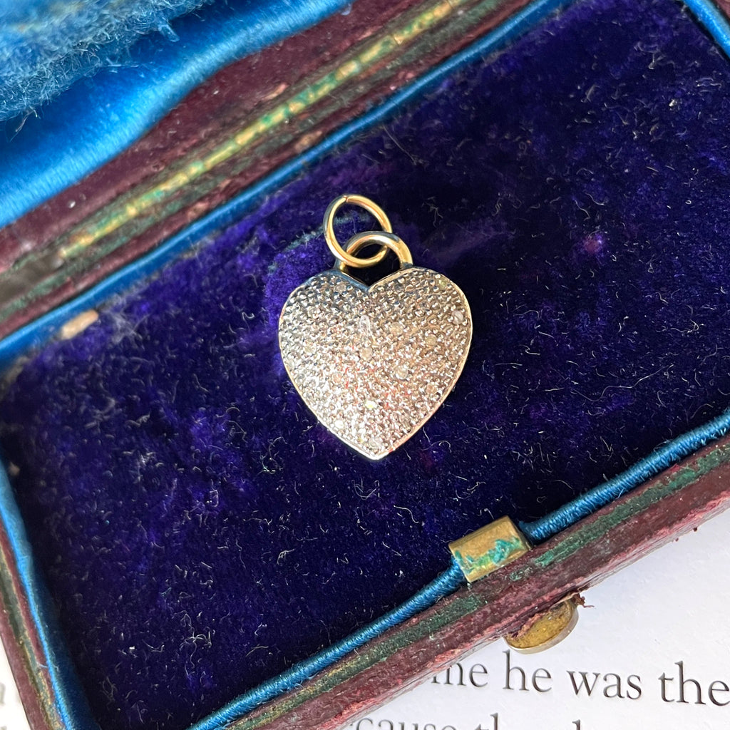 Hear-shaped pendant made of gold and diamonds on a blue velvet jewellery tray.