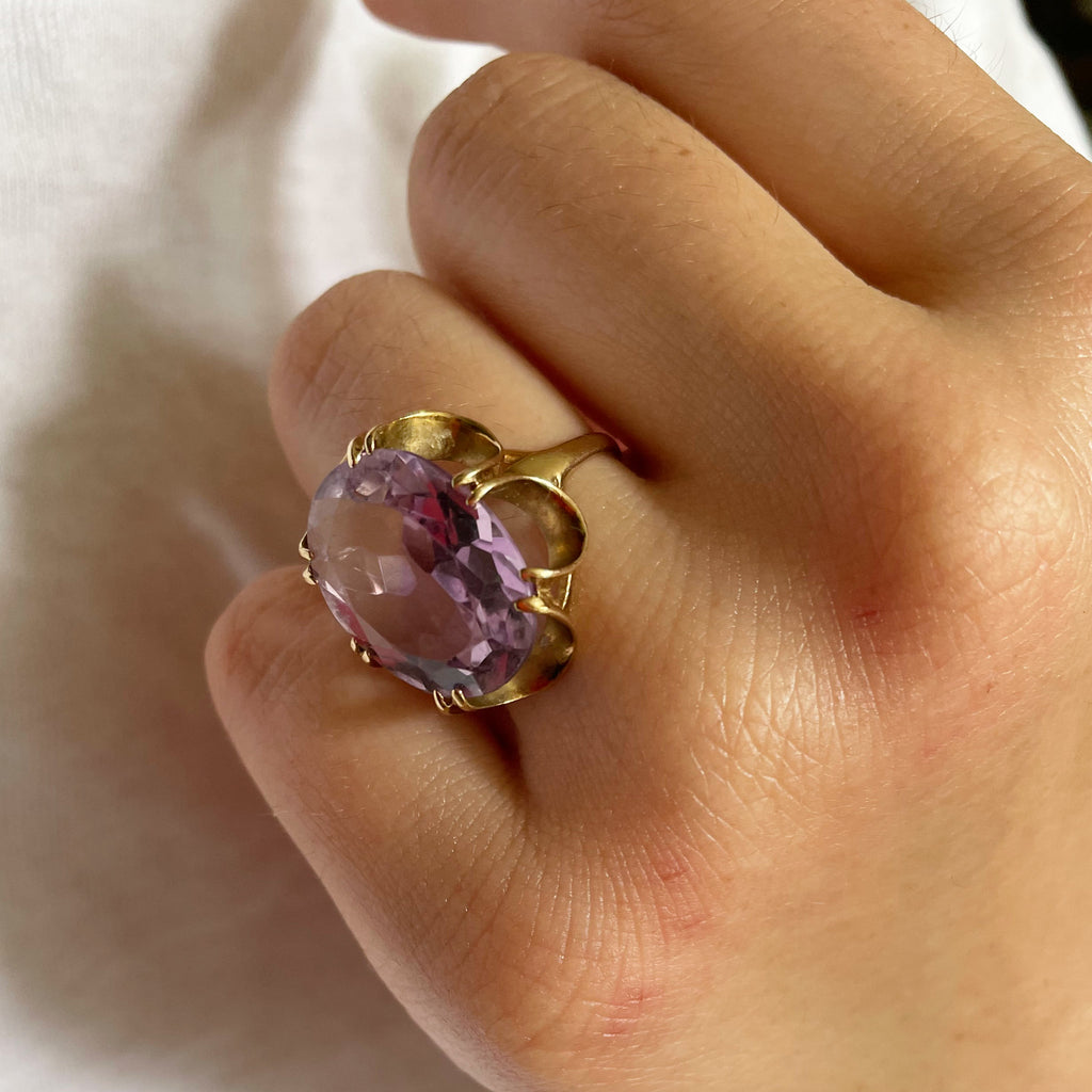 Large faceted amethyst ring with intricate gold shank and band.