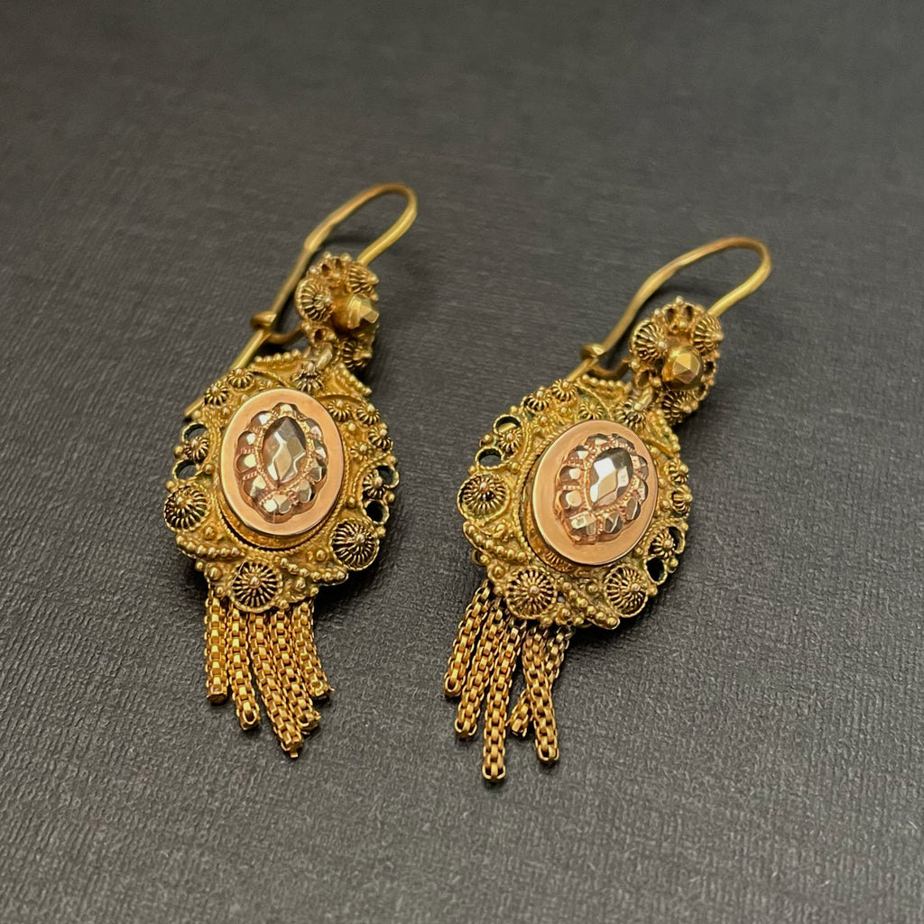 Intricately detailed gold earrings with tassels.