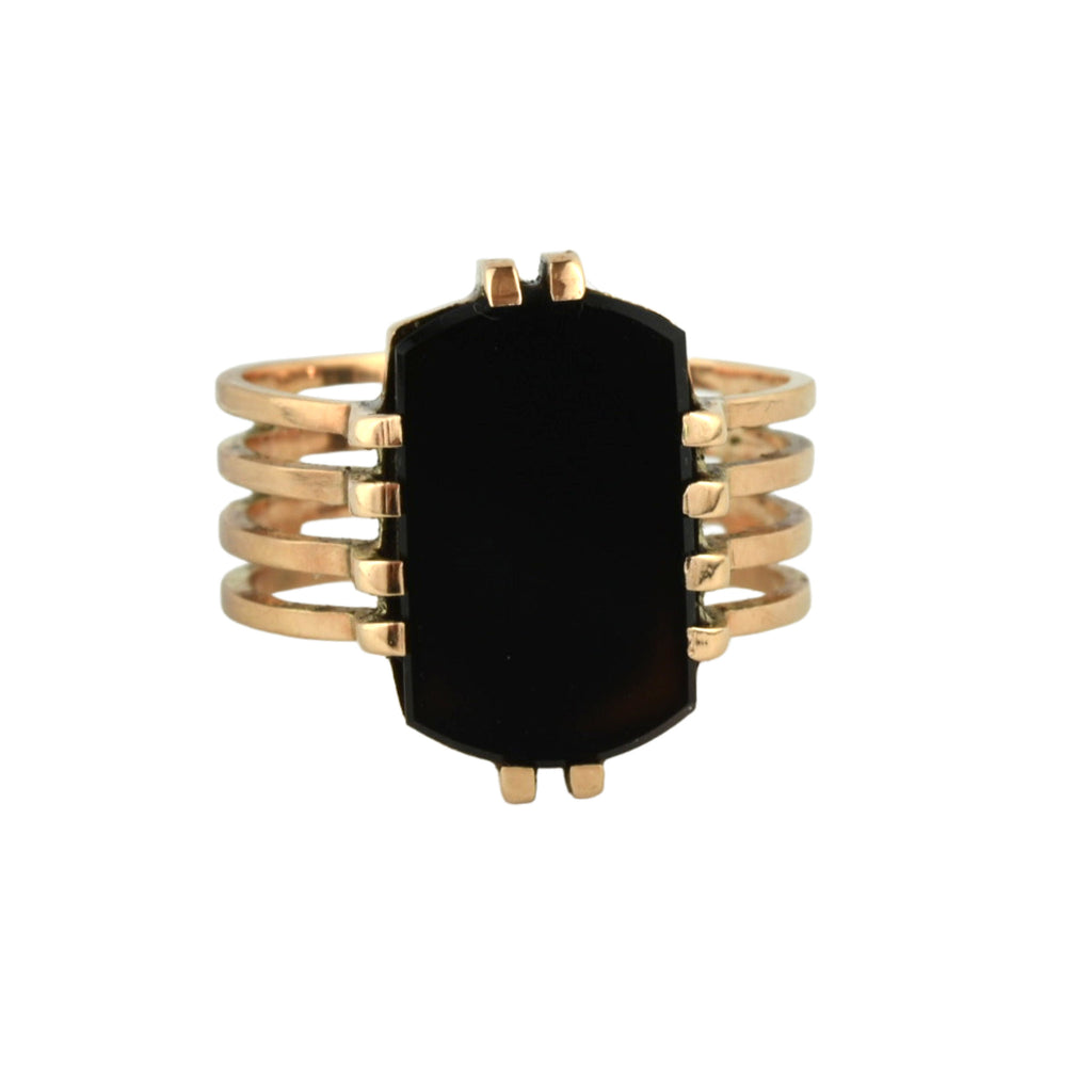 A black polished onyx ring with four bands of yellow gold.