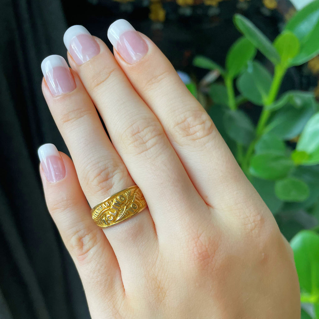 Victorian gold band ring on manicured hand.