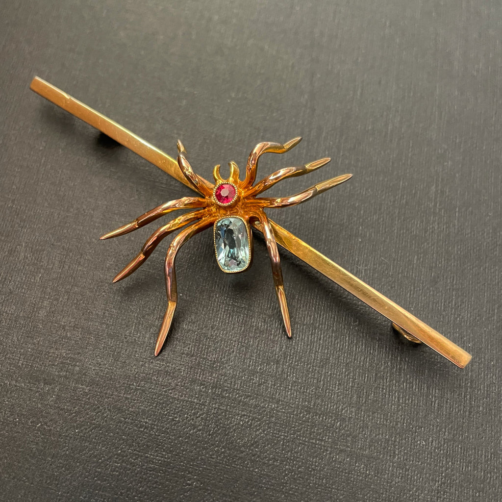 Gold spider brooch with ruby and aquamarine.